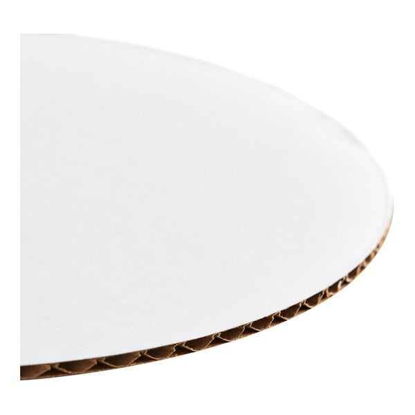 A round, white, corrugated grease-resistant cake circle.