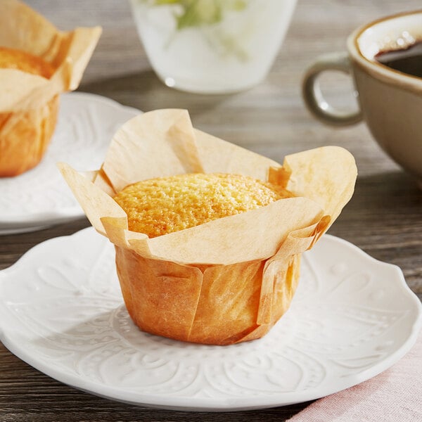 Two Baker's Mark unbleached natural kraft medium rounded muffins on a white plate.