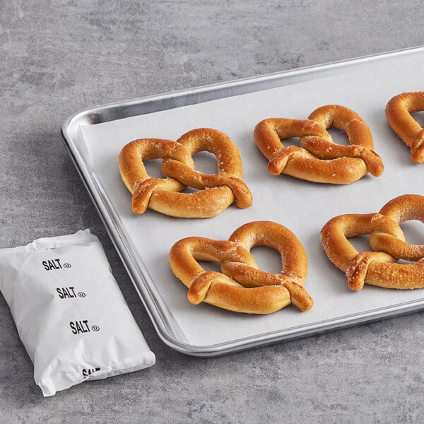 A tray of SuperPretzel whole grain soft pretzels with a packet of salt.