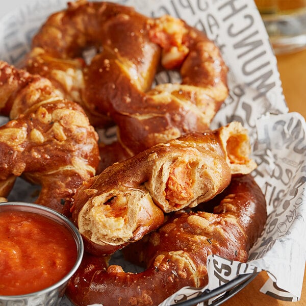 A bowl of Kim & Scott's Pizza Stuffed Soft Pretzels with red sauce.