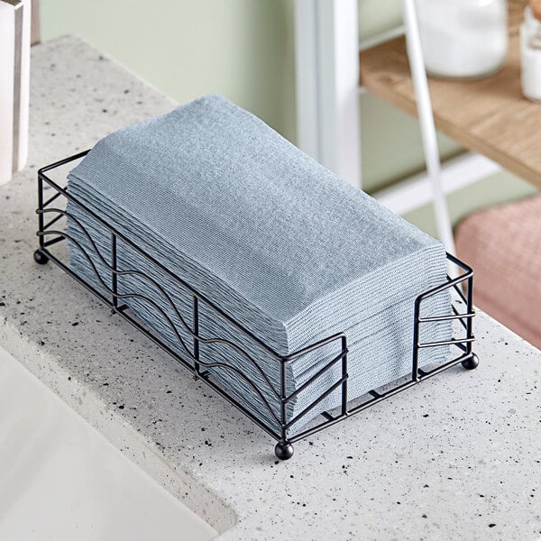 A black metal tray holding indigo Hoffmaster Linen-Like guest towels.