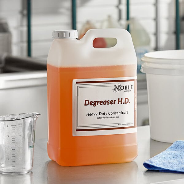 A white plastic jug of Noble Chemical heavy-duty degreaser on a counter.