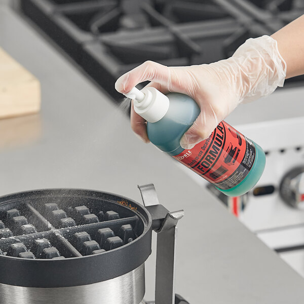 A person using Noble Chemical Formula-D Ready-to-Use Decarbonizer and Degreaser to clean a waffle iron.