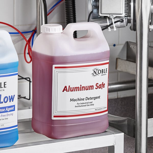 Two cases of Noble Chemical metal safe concentrated dishwashing liquid with a total of four jugs on a counter.