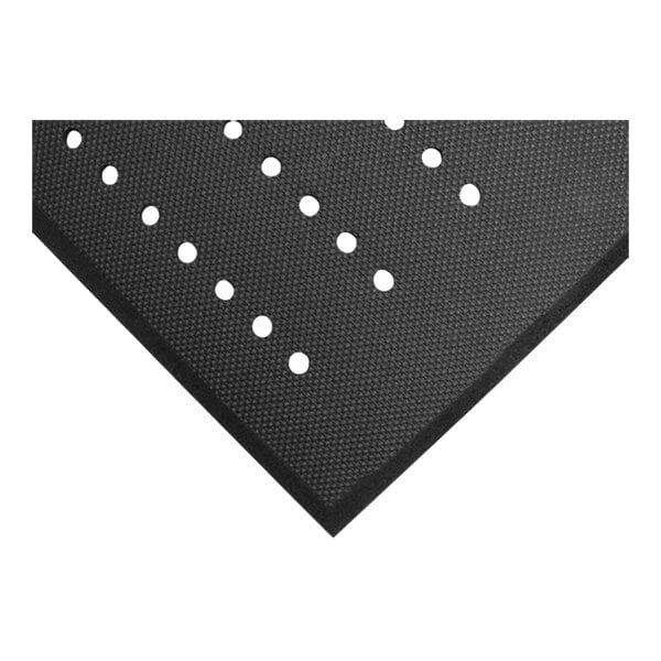 A close-up view of a black textured mat with evenly spaced round drainage holes and a beveled edge.