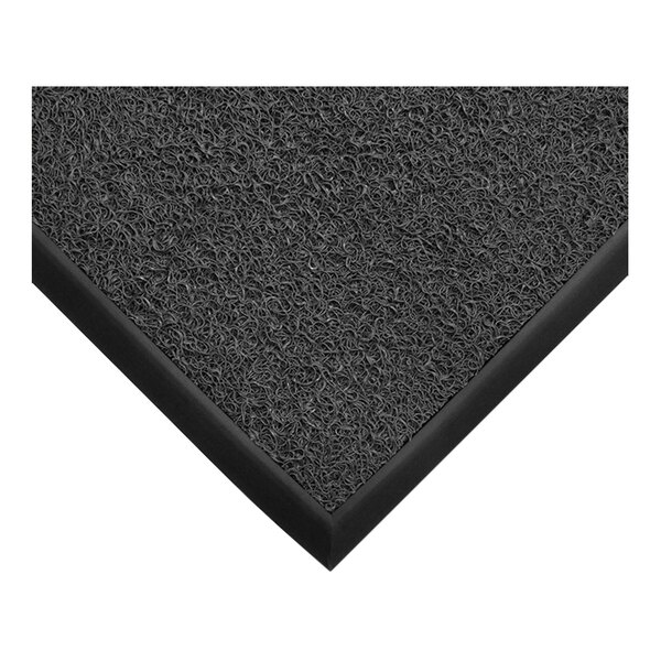 A close-up view of a dark gray mat with a textured, looped surface and a smooth black border.