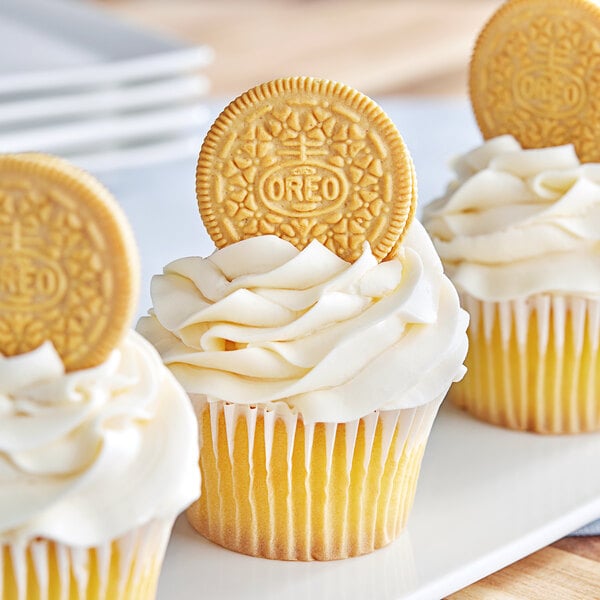 A close-up of a cupcake with a Nabisco Oreo cookie on top.