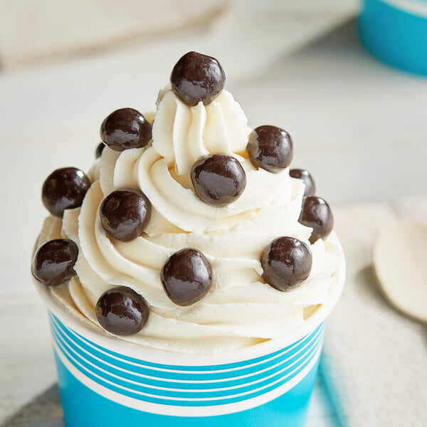 A cup of ice cream with Albanese Dark Chocolate Covered Pretzel Balls on top.