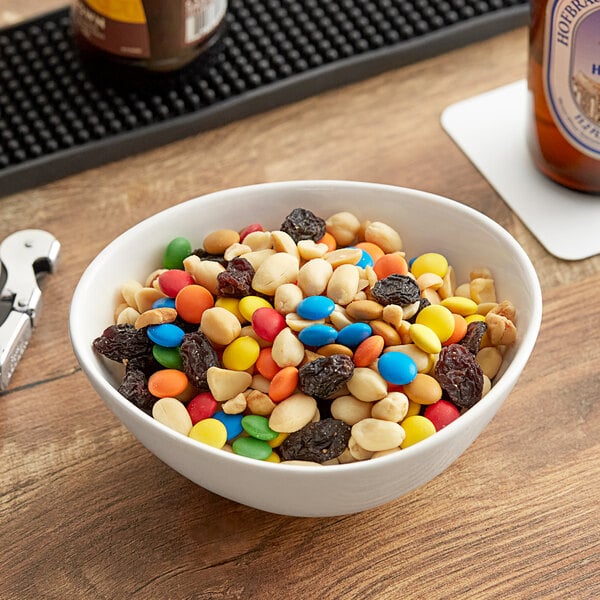 A bowl of nuts and candies on a table in a hotel buffet.