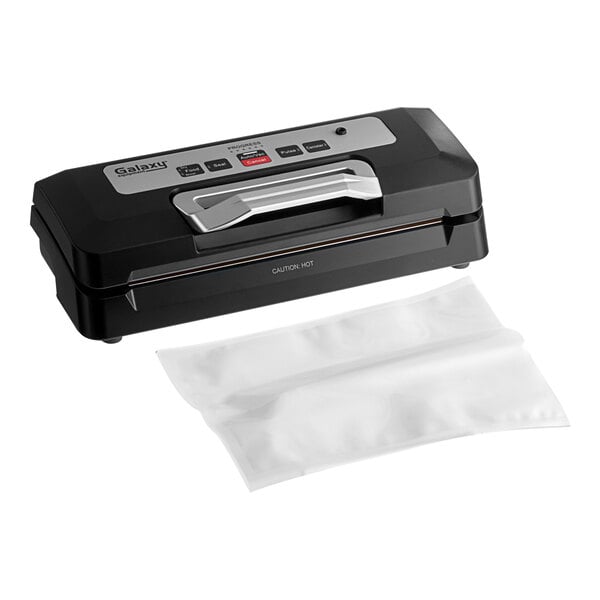 A black and silver Galaxy vacuum sealer with a white plastic bag being sealed.
