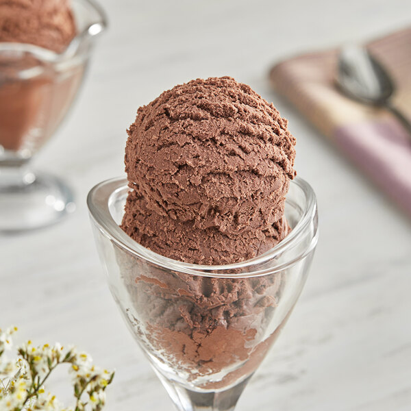 A scoop of I. Rice chocolate ice cream in a glass.