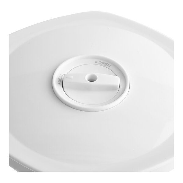 A white plastic lid with a round knob on a white object with a hole.