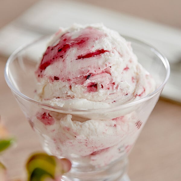 A glass bowl of blueberry variegate ice cream with berries.