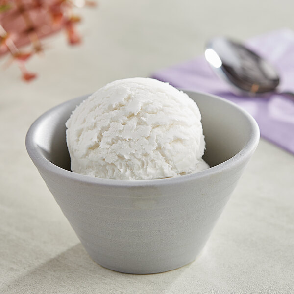 A bowl of I. Rice coconut hard serve ice cream with a spoon in it.