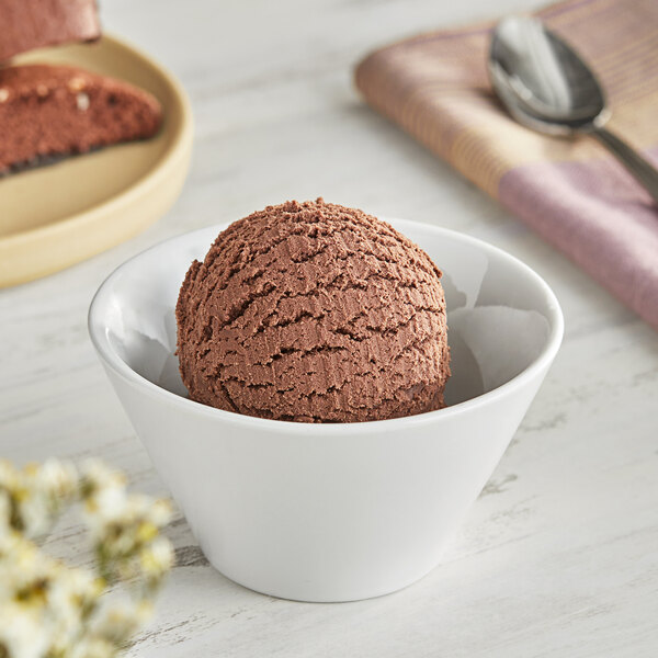 A bowl of chocolate ice cream with a scoop on a spoon.