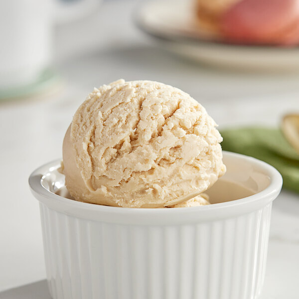 A bowl of I. Rice cookie dough hard serve ice cream with a scoop in it.