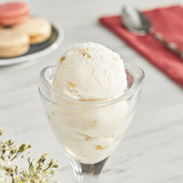 A glass with a scoop of I. Rice apple hard serve ice cream on a white background.