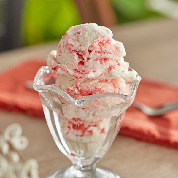 A glass bowl with a scoop of I. Rice strawberry variegate ice cream.