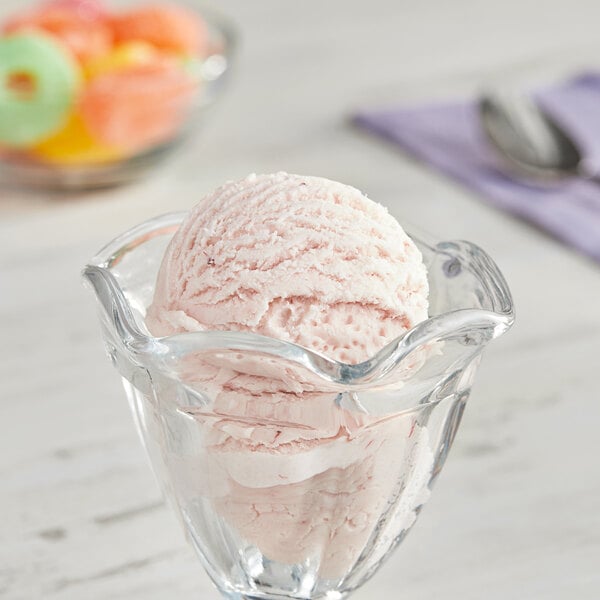 A bowl of strawberry ice cream with a scoop on top.