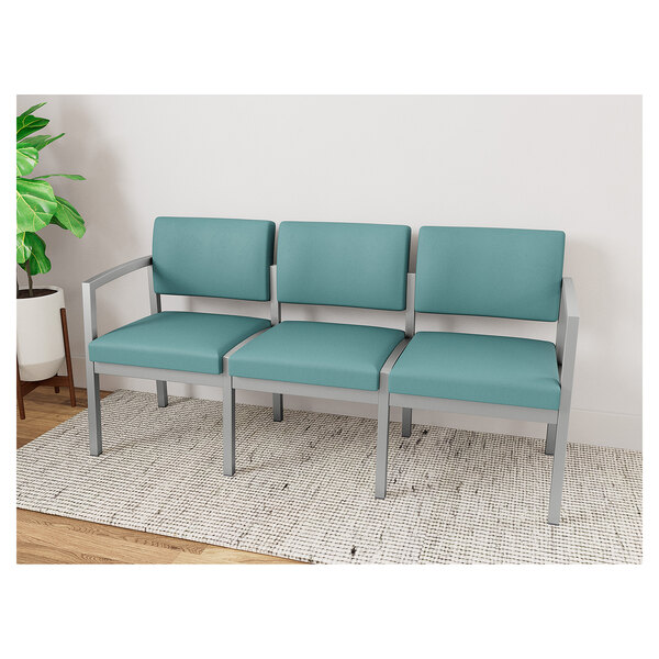 A row of blue Lesro Lenox Steel Patriot Plus vinyl chairs with silver legs.