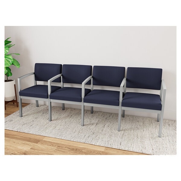 A Lesro Lenox navy blue upholstered sofa with white frame and center arms.