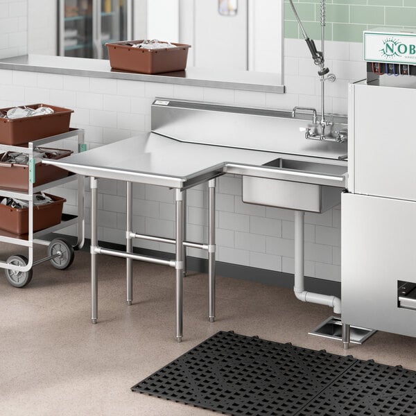 A Regency stainless steel L-shape dishtable with a sink on the counter.