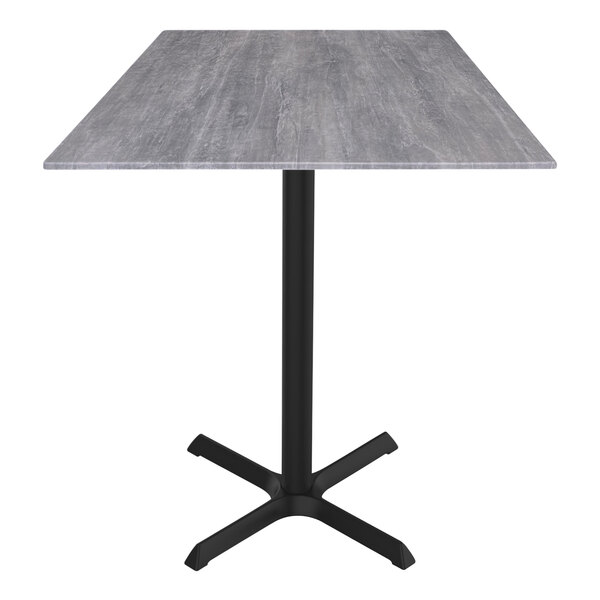 A Holland Bar Stool EuroSlim counter height table with a grey top and black cross base.