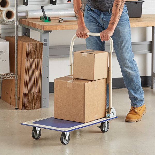 A man pushing a Lavex steel folding platform truck with boxes on it.