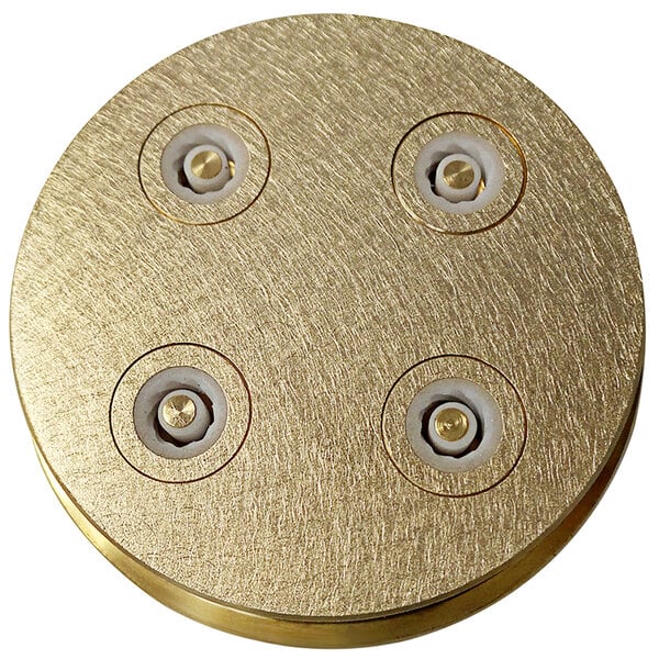A gold circular Sirman Paccheri pasta die with four holes.