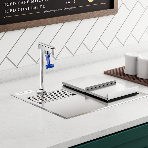 A Regency stainless steel water station with ice bin and glass filler on a counter with a faucet.