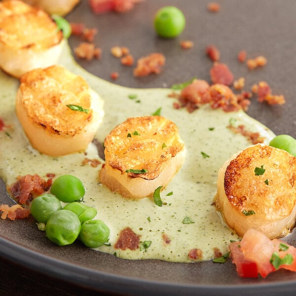 A plate of Mind Blown plant-based vegan scallops with peas and sauce.