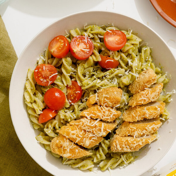 A plate of pasta with Jack & Annie's vegan plant-based chicken tenders and tomatoes.
