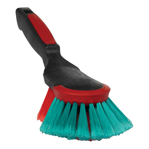 A Vikan red and black hand brush with green bristles.