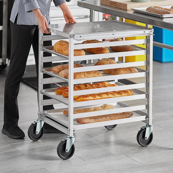 A woman opening an end load sheet pan rack filled with bread.