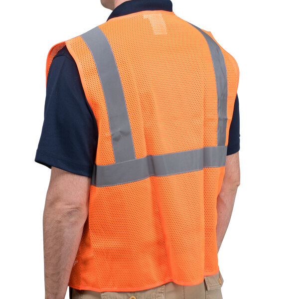 A person wearing a Cordova Orange high visibility safety vest with reflective stripes.