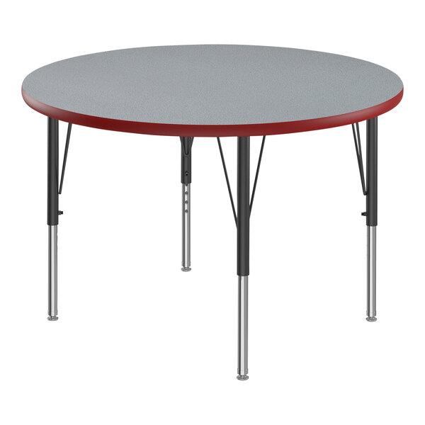 A Correll round activity table with a gray top and red legs.