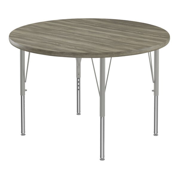 A Correll round activity table with metal legs and a gray driftwood top.