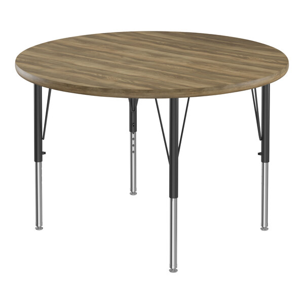 A Correll round activity table with hickory top and black metal legs.
