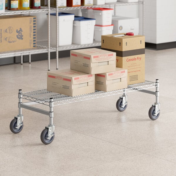 A Regency stainless steel dunnage rack cart with boxes on it.