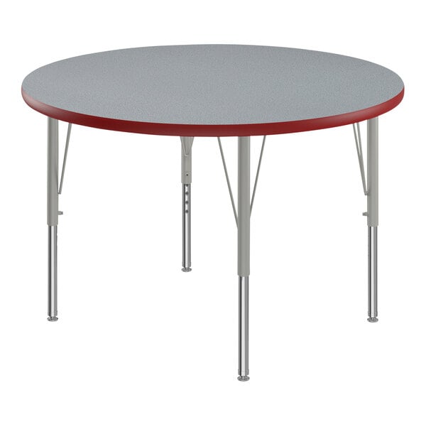 A round gray granite activity table with red T-mold on the edge.