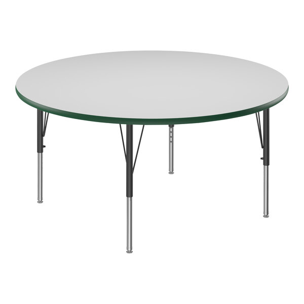 A Correll round white activity table with black and green legs.
