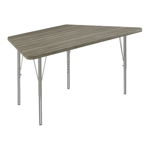 A Correll trapezoid activity table with a New England Driftwood high-pressure laminate top and silver legs.