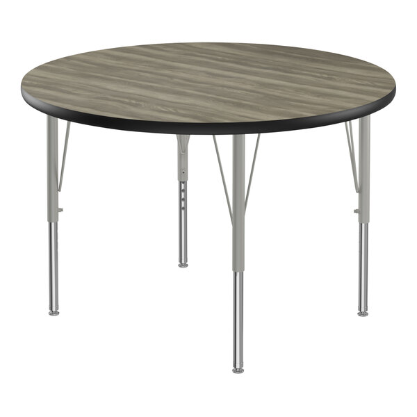 A Correll round activity table with metal legs and a wood top.