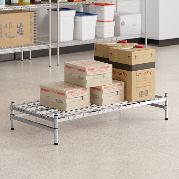 A Regency stainless steel wire shelf with boxes on it.