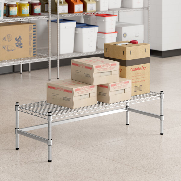 A Regency stainless steel wire dunnage rack shelf with boxes on it.