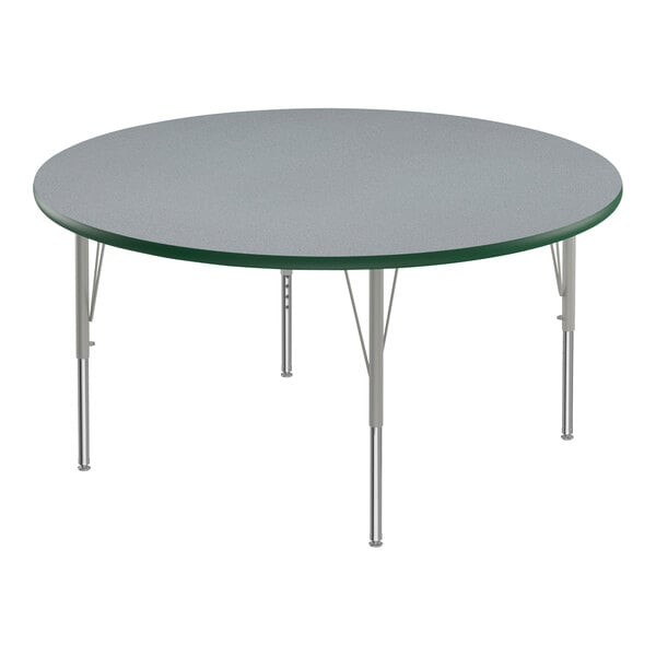 A round Correll activity table with metal legs and a gray top with green edging.