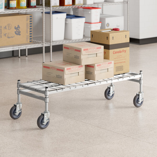 A Regency stainless steel wire rack cart with boxes on it.