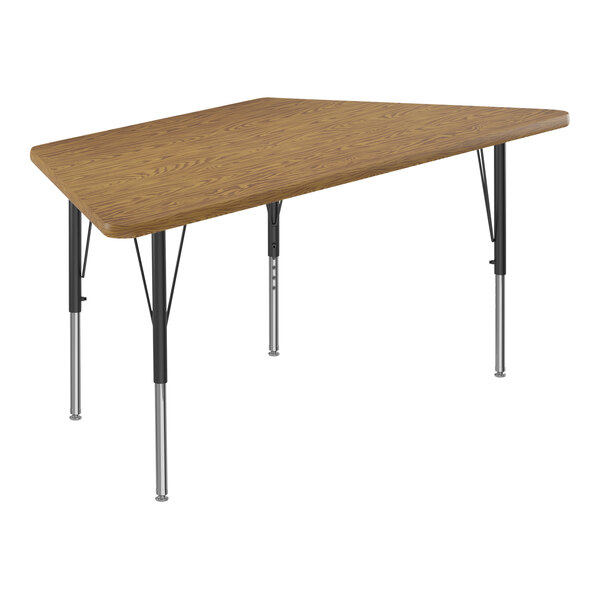 A trapezoid shaped Correll activity table with a medium oak top and black legs.