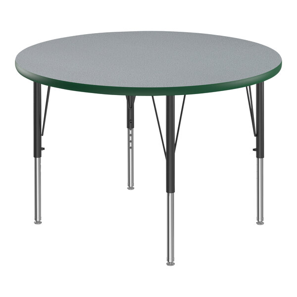 A round Correll activity table with a gray top and green border on black legs.