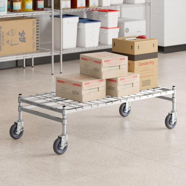 A Regency stainless steel wire cart with boxes on it.